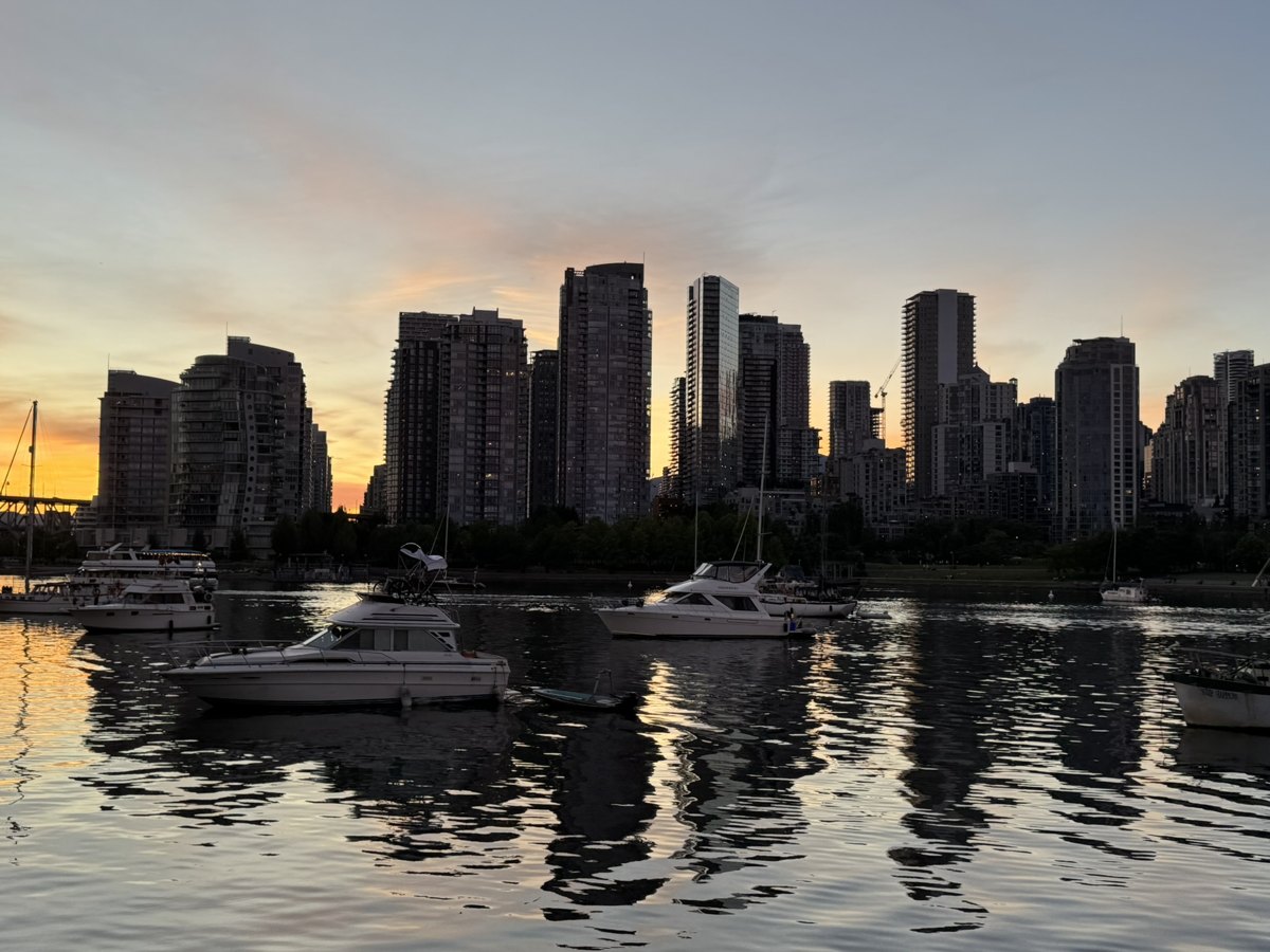 Dämmerung am False Creek in Vancouver mit Booten im Wasser und Hochhäusern vor orangefarbenem Himmel – Begleitfoto von Bernhard Houy