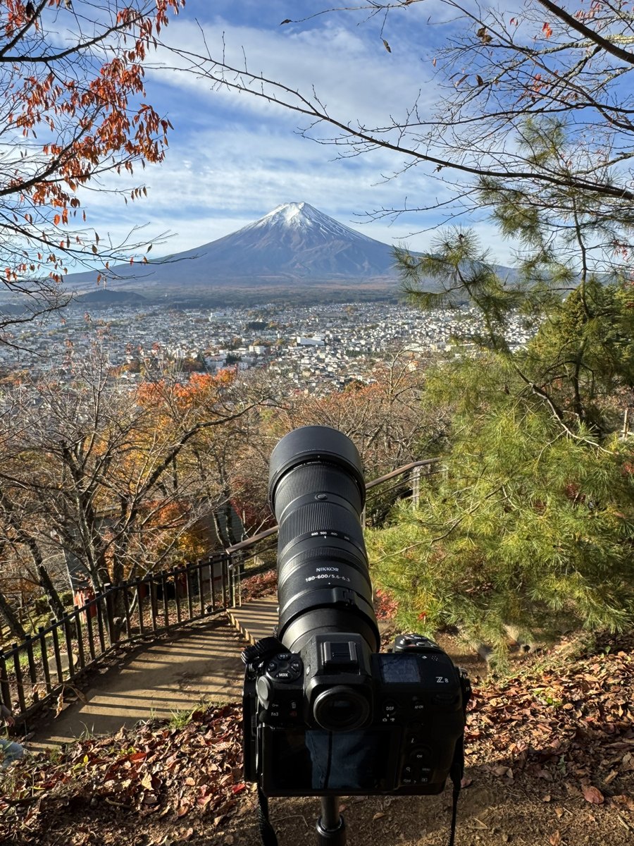 Kamera mit Teleobjektiv auf dem Stativ am Chureito-Aussichtspunkt, dahinter der Fuji – Begleitfoto von Bernhard Houy